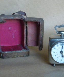 Despertador antiguo de viaje junto a su estuche de piel
