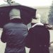 Pareja compartiendo un paraguas bajo la lluvia