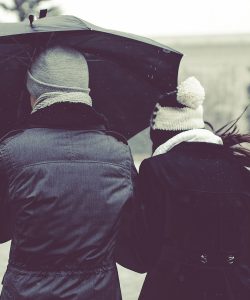 Pareja compartiendo un paraguas bajo la lluvia
