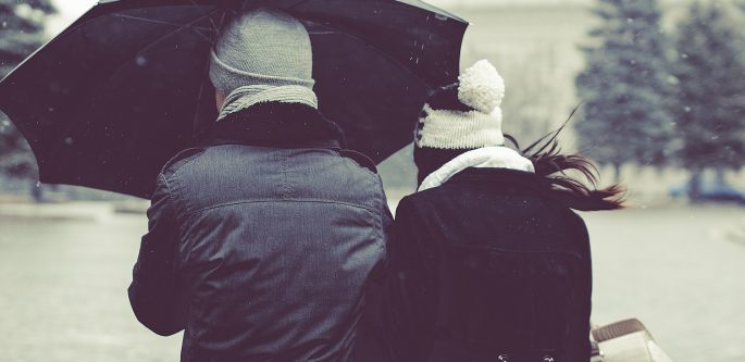 Pareja compartiendo un paraguas bajo la lluvia