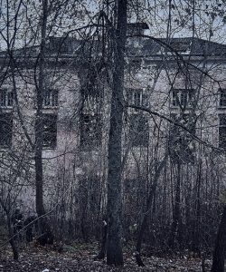 Edificio de un colegio abandonado entre árboles sin hojas