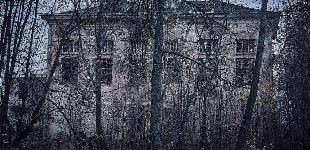 Edificio de un colegio abandonado entre árboles sin hojas